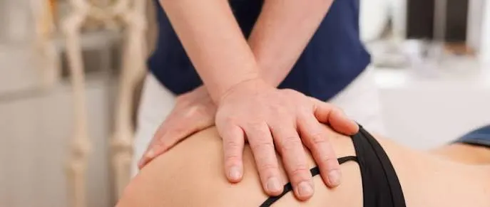 A physiotherapist working on a patient's lower back